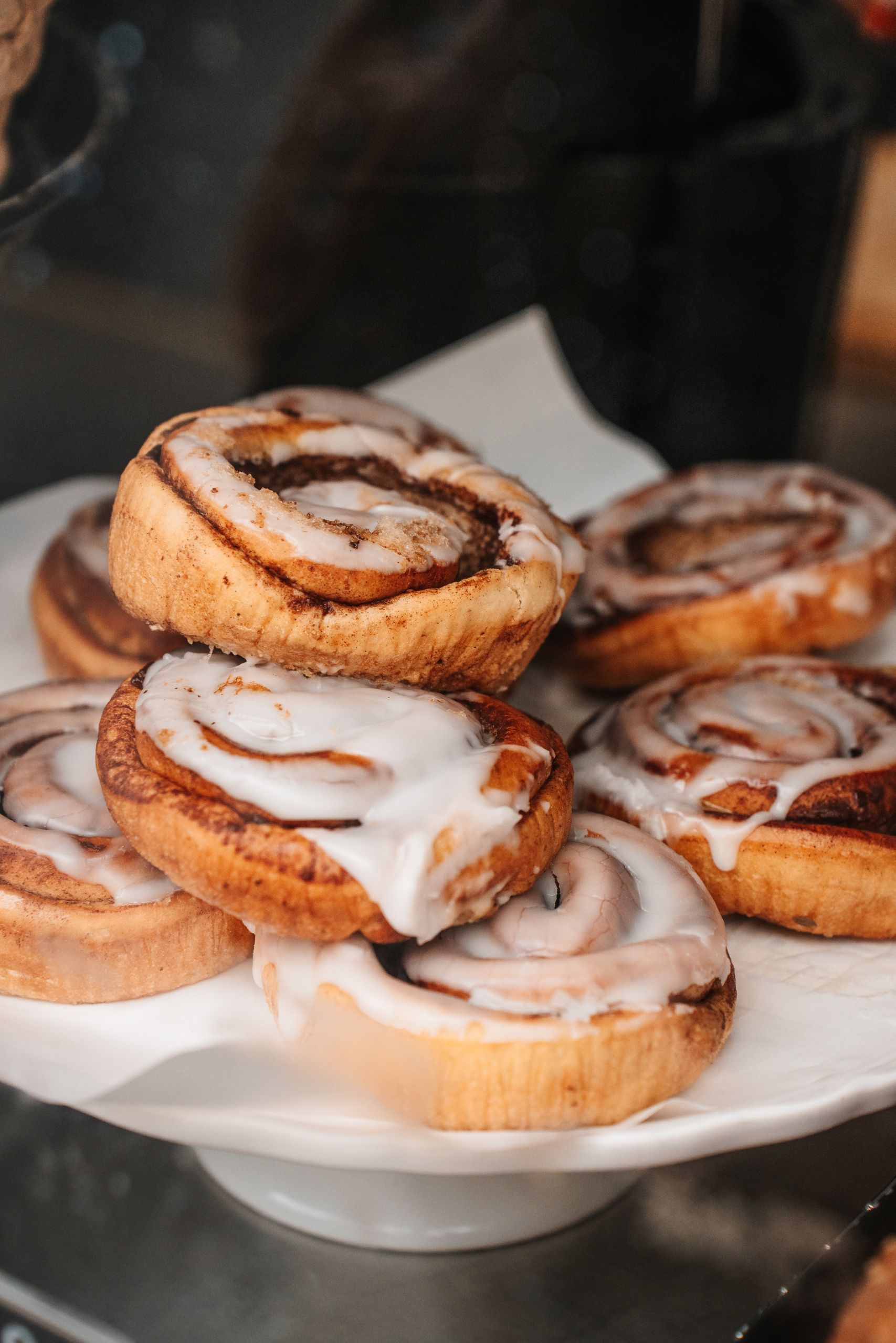 Close-up of delicious cinnamon rolls with icing on display, perfect for a sweet treat.